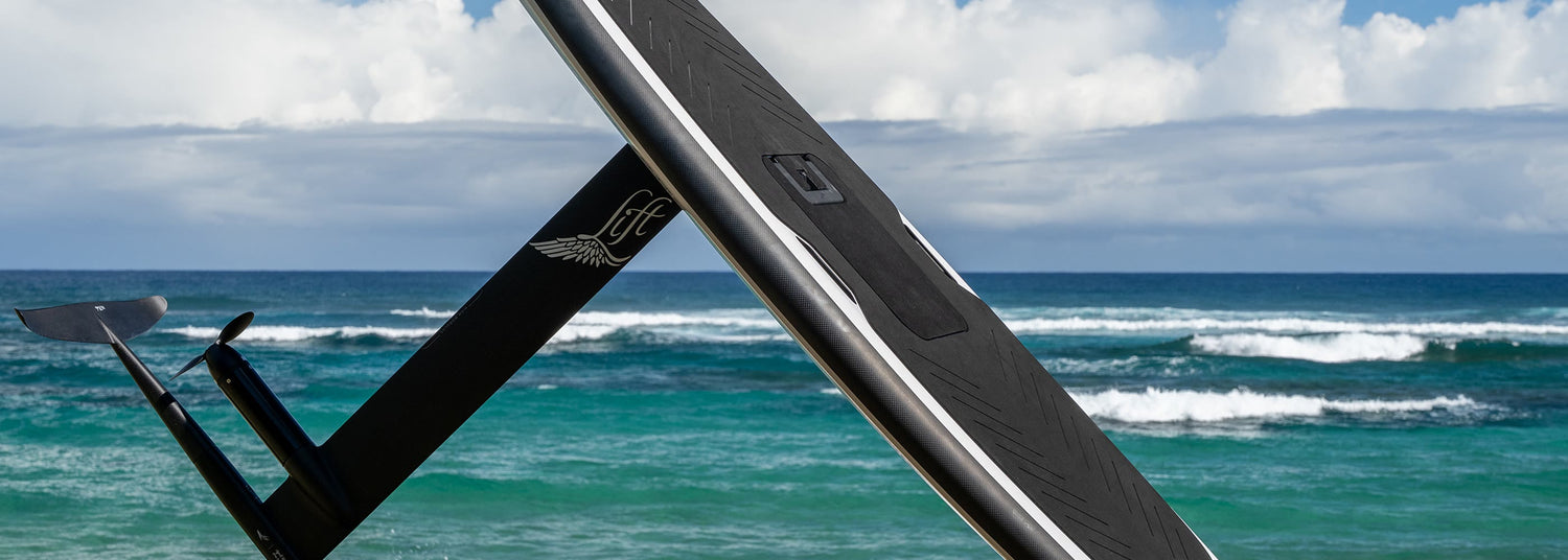 Close view of a Lift eFoil carbon board and mast beside the sea